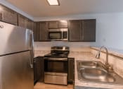 Thumbnail 14 of 20 - an updated kitchen with stainless steel appliances and granite counter tops. Fargo, ND Sunwood Apartments
