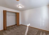 Thumbnail 13 of 20 - a bedroom area with a closet in a studio apartment.  Fargo, ND Sunwood Apartments  | Living and kitchen Fargo, ND Sunwood Apartments