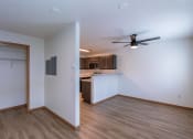Thumbnail 16 of 20 - an empty living room and kitchen with a ceiling fan. Fargo, ND Sunwood Apartments