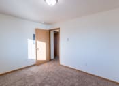 Thumbnail 9 of 20 - a bedroom with white walls and carpet.  Fargo, ND Sunwood Apartments  | Living and kitchen Fargo, ND Sunwood Apartments
