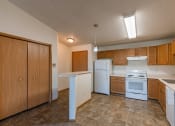 Thumbnail 7 of 20 - a kitchen with white appliances and wooden cabinets.  Fargo, ND Sunwood Apartments  | Living and kitchen Fargo, ND Sunwood Apartments