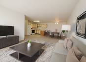 Thumbnail 2 of 28 - Fargo, ND Thunder Creek Apartments. The room is furnished with comfortable seating, a coffee table, and tasteful decor, creating a warm and inviting atmosphere for relaxation and entertainment. A dining room and kitchen are in the background