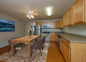 Thumbnail 5 of 28 - Fargo, ND Thunder Creek Apartments. A modern and well-equipped kitchen and dining area.. The space features sleek appliances, a spacious dining table, and tasteful decor, creating an inviting and functional environment for cooking and dining
