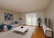Thumbnail 4 of 28 - Fargo, ND Thunder Creek Apartments. A living room with a couch, coffee table, tv, and wood flooring.
