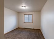 Thumbnail 21 of 28 - an empty room with carpet and a window. Fargo, ND Thunder Creek Apartments