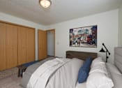 Thumbnail 3 of 16 - Fargo, ND Twin Parks Apartments. a bedroom with a bed and a chair in a room