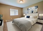 Thumbnail 5 of 45 - a bedroom with a bed and a painting on the wall. Fargo, ND Urban Plains Apartments