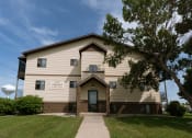 Thumbnail 2 of 2 - Fargo, ND Village Park Apartments. An image of the front of a large building with a water tower in the background
