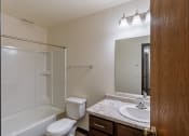 Thumbnail 24 of 26 - a bathroom with a sink and a toilet and a shower. Fargo, ND Village West Apartments
