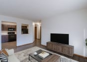Thumbnail 7 of 26 - a living room with a couch and a tv and a kitchen. Fargo, ND Village West Apartments