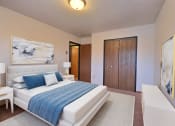 Thumbnail 4 of 26 - a bedroom with a bed and a chair in a room. Fargo, ND Village West Apartments