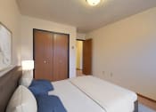 Thumbnail 5 of 26 - a bedroom with a bed and a wardrobe. Fargo, ND Village West Apartments