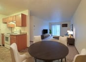Thumbnail 2 of 26 - a dining area with a table and chairs and a kitchen in the background. Fargo, ND Village West Apartments