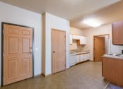 Thumbnail 9 of 61 - the view of a kitchen and a living room with wooden doors. Fargo, ND West Lake Apartments