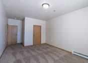 Thumbnail 13 of 61 - a bedroom with carpet and a door to a bedroom. Fargo, ND West Lake Apartments