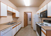 Thumbnail 8 of 61 - a kitchen with a stove refrigerator and sink. Fargo, ND West Lake Apartments