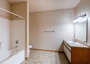 Thumbnail 15 of 61 - the view of a bathroom with a tub and a sink and a mirror. Fargo, ND West Lake Apartments