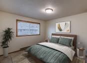 Thumbnail 4 of 9 - a bedroom with a bed and a potted plant. Fargo, ND West Oak Apartments