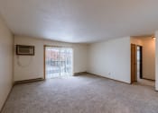 Thumbnail 6 of 9 - the living room of an apartment with a sliding glass door. Fargo, ND West Oak Apartments.