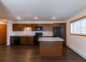 Thumbnail 35 of 42 - a kitchen with black appliances and an island with a window. Fargo, ND Westwood Apartments