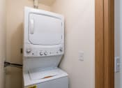 Thumbnail 41 of 42 - a laundry closet with a washer and dryer on top of each other. Fargo, ND Westwood Apartments