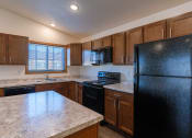 Thumbnail 24 of 42 - a kitchen with black appliances and white countertops. Fargo, ND Westwood Apartments