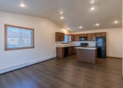 Thumbnail 23 of 42 - a kitchen and living room with two windows on the left. Fargo, ND Westwood Apartments