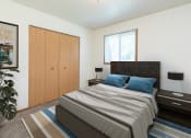 Thumbnail 4 of 13 - a bedroom with a bed and a closet and a window. Fargo, ND White Ridge Apartments