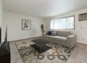Thumbnail 3 of 13 - a living room with a couch and a coffee table with a window in the back. Fargo, ND White Ridge Apartments