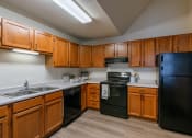 Thumbnail 19 of 24 - a kitchen with black appliances and white countertops. Fargo, ND Willow Park Apartments