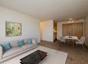 Thumbnail 2 of 9 - Fargo, ND Windgate Apartments. a living room with a couch a table and a ceiling fan