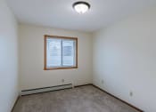 Thumbnail 6 of 15 - the living room with carpet and a window. Fargo, ND Windsor Apartments