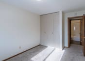 Thumbnail 7 of 15 - a bedroom with a closet and a door to a bathroom. Fargo, ND Windsor Apartments
