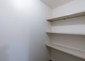 Thumbnail 10 of 15 - a room with white walls and shelves on the wall. Fargo, ND Windsor Apartments