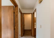 Thumbnail 11 of 15 - a hallway with wooden doors and a door to a bathroom. Fargo, ND Windsor Apartments
