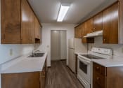 Thumbnail 13 of 15 - an empty kitchen with white appliances and wooden cabinets. Fargo, ND Windsor Apartments