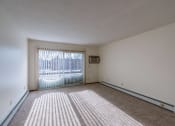Thumbnail 12 of 15 - the living room of an apartment with a sliding glass door. Fargo, ND Windsor Apartments