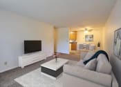Thumbnail 2 of 17 - a living room with a couch and a coffee table. Fargo, ND Woodland Apartments