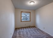 Thumbnail 12 of 17 - a bedroom with carpet and a window. Fargo, ND Woodland Apartments
