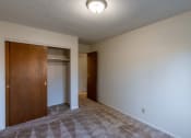 Thumbnail 11 of 17 - a bedroom with a door to a closet. Fargo, ND Woodland Apartments