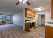 Thumbnail 7 of 17 - an empty kitchen and living room with a stove refrigerator and sink