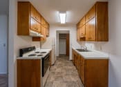 Thumbnail 8 of 17 - a kitchen with white appliances and wood cabinets. Fargo, ND Woodland Apartments