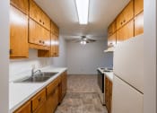 Thumbnail 9 of 17 - a kitchen with white appliances and wooden cabinets. Fargo, ND Woodland Apartments