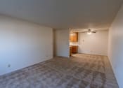 Thumbnail 6 of 17 - an empty living room with white walls and a ceiling fan. Fargo, ND Woodland Apartments
