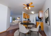 Thumbnail 5 of 11 - a living room and dining room with a kitchen and a ceiling fan. Moorhead, MN Woodstone Apartments