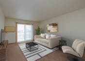 Thumbnail 2 of 11 - the living room of an apartment with a couch and a coffee table. Moorhead, MN Woodstone Apartments