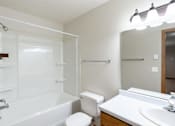 Thumbnail 24 of 26 - a bathroom with a shower toilet and sink and a mirror. Fargo, ND Briar Pointe Apartments