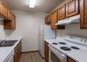 Thumbnail 16 of 26 - an empty kitchen with white appliances and wooden cabinets. Fargo, ND Briar Pointe Apartments