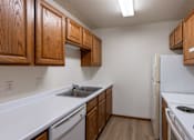 Thumbnail 17 of 26 - an empty kitchen with white appliances and wooden cabinets.Fargo, ND Briar Pointe Apartments