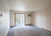 Thumbnail 14 of 26 - the living room of an apartment with carpet and a door to the patio. Fargo, ND Briar Pointe Apartments